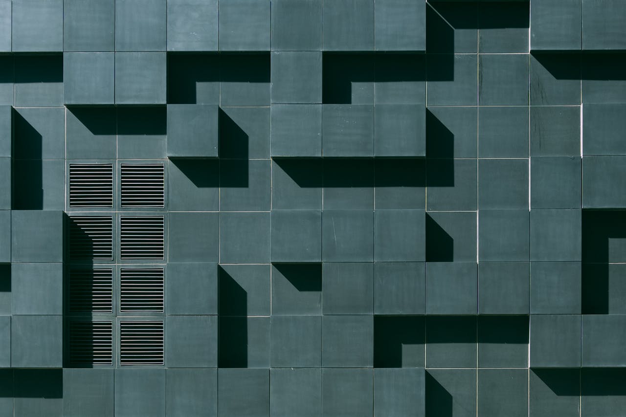 Abstract geometric facade in Oslo with tiles, grids, and shadows creating a minimalist design.